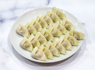 Steamed dumplings on white plate, ready to eat