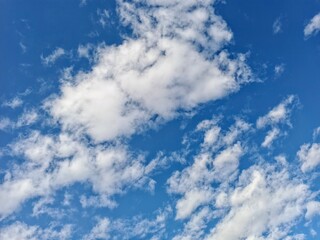 Fototapeta premium Fluffy white clouds in blue sky isolated on