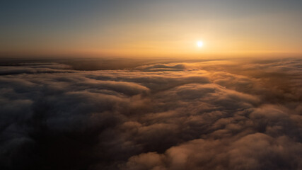 Fototapeta premium Golden sunrise illuminating a vast sea of clouds from above, creating a serene atmosphere