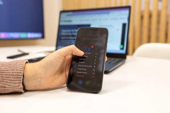Hand holding phone uninstalling facebook social media app