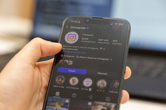 Hand holding smartphone browsing social media instagram app