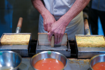 Hands on the chef cooking the egg roll. Japanese food