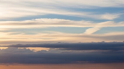 Vibrant layers of clouds at sunset with a distant contrail.