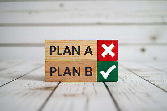 Wooden blocks stacked on a light plank, featuring 'PLAN A' with an 'X' and 'PLAN B' with a checkmark, representing choices in problem-solving. Clean, professional look.
