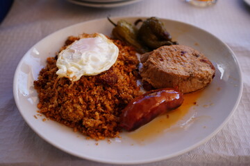 Traditional migas completas from Montes de Málaga on white plate
