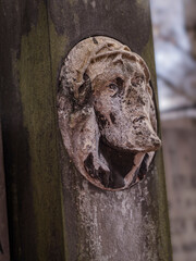 Weathered mourning Jesus-Head Relief on Monolithic Monument in Aged Cemetery Setting