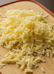 Grated Cheese on Wooden Cutting Board
