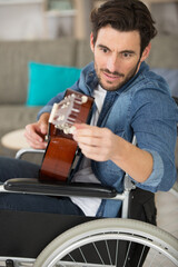 handicapped guitarist tuning a guitar