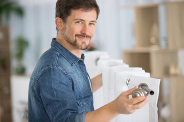 young handsome man hanging window curtain in room © auremar