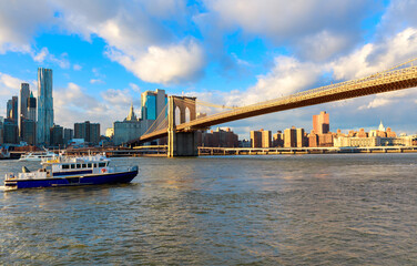 Obraz premium View of Brooklyn Bridge and boat on East River in New York City during clear day