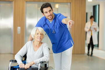 Obraz premium male nurse looking at senior woman in wheelchair