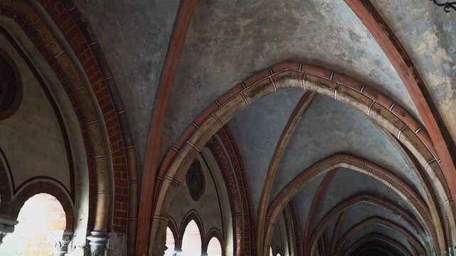 A detailed view of impressive Early Gothic ribbed vaults and arched ceilings in the Riga Dome cloister. Ancient stone and brickwork reveal the grandeur of medieval Latvian architecture.