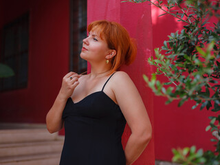 Young woman in elegant black dress walking in cozy old town Keleci, Antalya, Turkey during summer day. female traveler discover interesting places and popular attractions