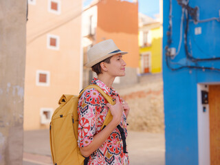 Woman in dress strolls through colorful streets of Spanish coastal town of La Vila Joiosa or Villajoyosa. sunny winter atmosphere highlights charm of Mediterranean architecture and quiet seaside life