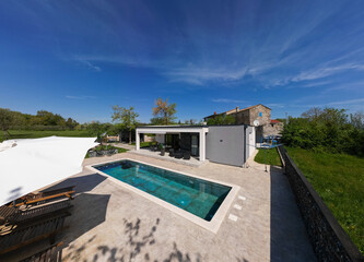 Aerial view of a modern modular house with flat roof, swimming pool, and patio. Contemporary...