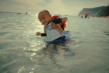 A joyful child plays happily in the water, showcasing the true fun of delightful family beach...