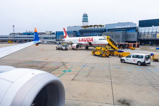 Vienna, Austria - 15 December, 2025: Lauda airline aircraft at Vienna International Airport. Ground crew and vehicles are present, showcasing airport operations and travel logistics.