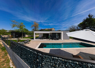 Aerial view of a modern modular house with flat roof, swimming pool, and patio. Contemporary...