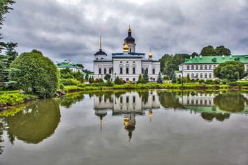 Monastery grounds with a pond and a view of the Cathedral of the Three Holy Hierarchs. Spaso-Eleazarovsky Convent. Elizarovo village, Pskov Oblast, Russia
