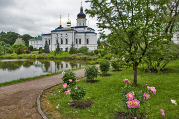 Monastery grounds with a pond and a view of the Cathedral of the Three Holy Hierarchs. Spaso-Eleazarovsky Convent. Elizarovo village, Pskov Oblast, Russia