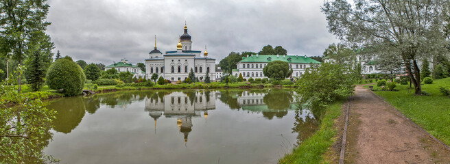 Monastery grounds with a pond and a view of the Cathedral of the Three Holy Hierarchs. Spaso-Eleazarovsky Convent. Elizarovo village, Pskov Oblast, Russia