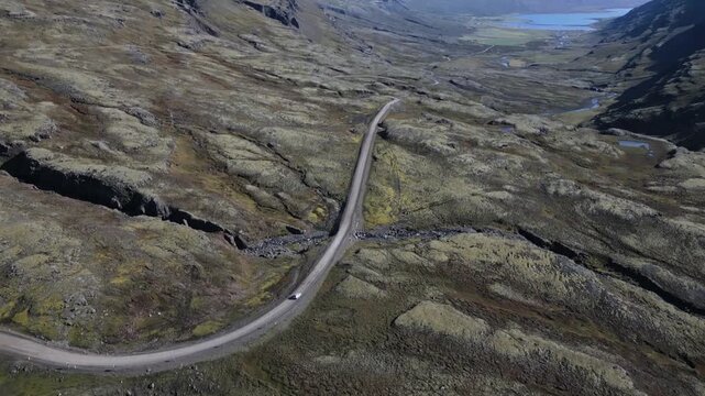 Cinematic aerial drone view of scenic volcanic landscape with blue lake, green moss and mountains in Iceland 4K