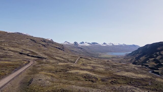 Cinematic aerial drone view of scenic volcanic landscape with blue lake, green moss and mountains in Iceland 4K