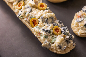 Bread Topped with Cheese Mixture and Olives – Ready to Bake