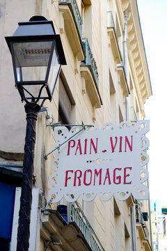 Paris, France, Europe. Side street with charming old streetlamp and sign that reads Bread, Wine and Cheese in French