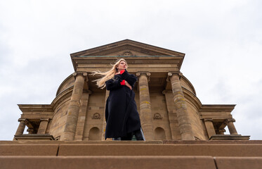 Beautiful woman standing in front of medieval chapel, low angle view