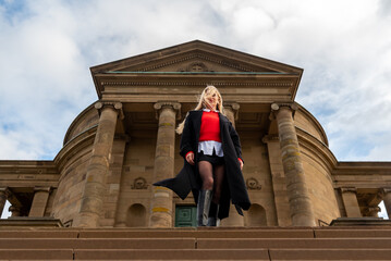Elegant woman with tousled hair standing in front of a medieval building