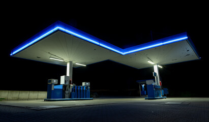 Gas station with blue neon lights on the road side, night photography