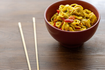 Close-Up of Curry Chicken Noodles in a Red Bowl
