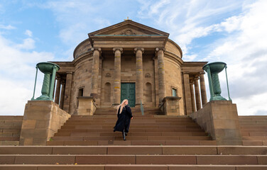 Woman climbing stairs to a medieval chapel on a sunny winter day