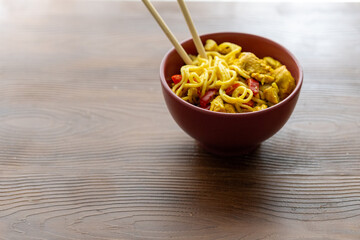 Close-Up of Curry Chicken Noodles in a Red Bowl
