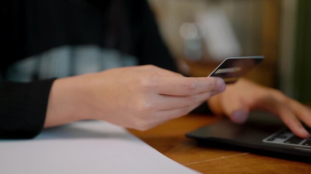 Anxious Asian woman looking at a blocked credit card during online shopping. She is burdened by debt and inflation, representing the financial struggle of the credit collapse trend in 2026.
