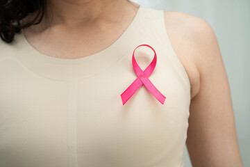 Asian woman with pink ribbon for October world breast cancer day.