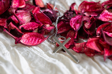 Close-Up of Dried Rose Petals and Metal Cross