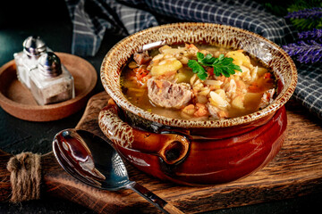 Pea soup with pieces of white sausage, potatoes and small dumplings.