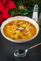 Pea soup with pieces of white sausage, potatoes and small dumplings.
