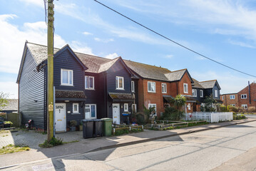 Exterior of old terraced houses along a street in England on a sunny spring day. Lens flare.