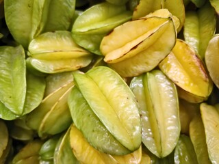 Star fruits with five-ridge shape in green-yellow tones showing natural ripeness and texture
