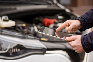 Car Diagnostic Test. Computer Diagnostics for Electric Car. Driving Test. Mechanic Serviceman using Scanner to Check Diagnose Car Problem.