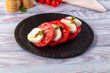 Italian Caprese salad with tomato, mozarella and pesto