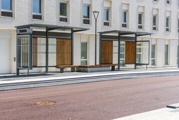 Deserted bus stop with shelters and benches along a street in a city centre