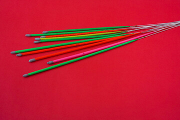 Colorful unlit sparkler sticks isolated on red background, party decoration concept with copy space for celebration and holiday themes