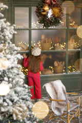 A little girl, seen from behind, near a French bakery. The child is wearing a cozy bright pink outfit and a white beret. Snow-covered trees, warm golden lights, Christmas decorations, and a magical