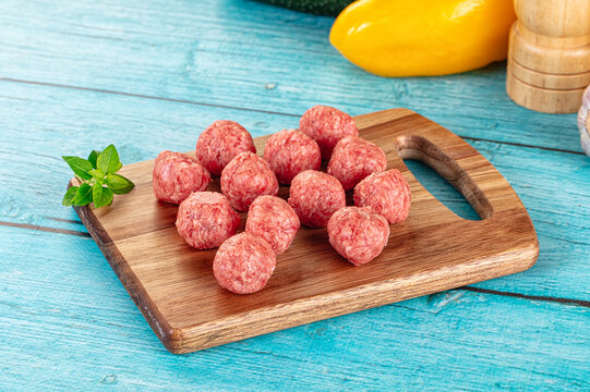 Raw beef meatballs over board