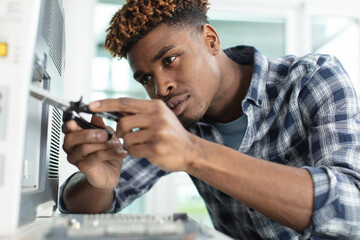 young service contractor assembling oven using pliers
