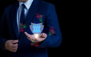Businessman holding digital shield with bank icon, representing secure banking, financial data protection, fintech and cybersecurity technology.